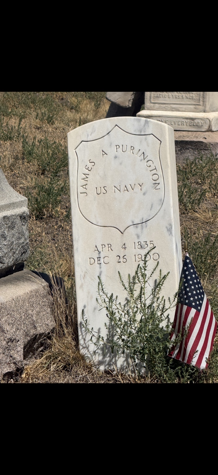 James A. Purington’s U.S. Navy headstone at Riverside Cemetery in Denver, decorated with an American flag
